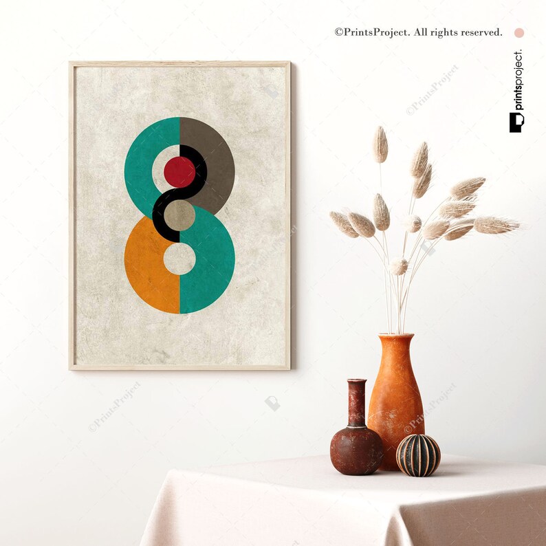 May include: Abstract geometric print with a teal, orange, gray, black, and red color scheme. The print is on a textured, beige background and is framed in a light wood frame.