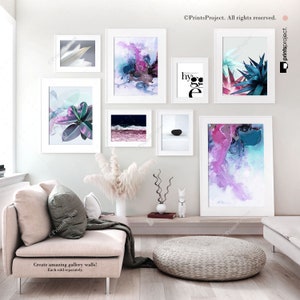May include: A set of eight framed prints featuring abstract art, nature scenes, and typography. The prints are arranged in a gallery wall style on a white wall. The prints are all in white frames.