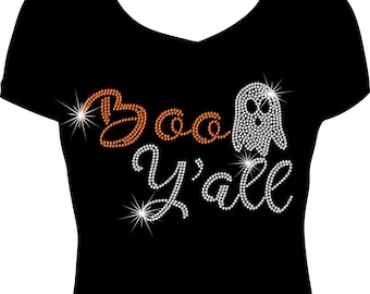 May include: Black V-neck t-shirt with the phrase "Boo Y'all" in rhinestone lettering. The word "Boo" is in orange, and the ghost and "Y'all" are in white. The design includes starburst accents, perfect for Halloween.