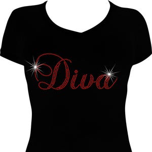 May include: Black V-neck t-shirt with the word "Diva" in red rhinestones. The word is embellished with starburst accents on each side. The shirt is a solid black color.