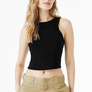 May include: A black sleeveless tank top with a high neckline and a cropped hemline, paired with khaki-colored trousers featuring a wide waistband and a visible front button closure. The top is made of a solid black fabric with a ribbed texture.