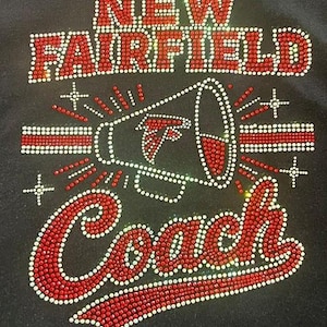 Pode incluir: Uma superfície de tecido preto com um design de strass apresentando o texto NEW FAIRFIELD em cristais vermelhos e brancos. Abaixo do texto há um gráfico de megafone com um logotipo de pássaro e a palavra Coach em cristais vermelhos e brancos.