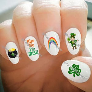 May include: Set of five nail decals featuring St. Patrick's Day themed designs. The decals include a pot of gold, a rainbow, a leprechaun, a shamrock, and the text "Kiss Me I'm Irish".
