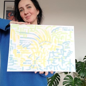 Könnte beinhalten: Ein rechteckiger weißer Kunstdruck mit einem abstrakten Muster aus hellgelben und blassblauen Pinselstrichen. Das Design besteht aus verschiedenen geschwungenen Linien, Strichen und kreisförmigen Formen, die in einer rhythmischen Komposition angeordnet sind.