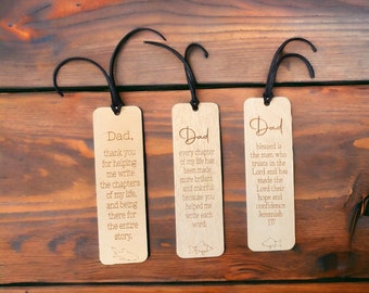 May include: Three wooden bookmarks with laser-engraved messages for a father. The bookmarks feature a fish design and a black ribbon.