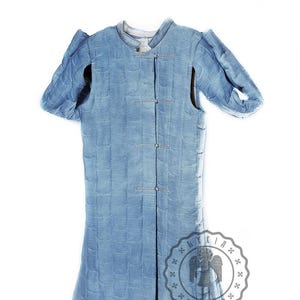 Puede incluir: Una prenda acolchada azul con mangas largas y cierre de botones. La prenda tiene un logotipo "LYKIA ARMOUR" en la parte inferior derecha.