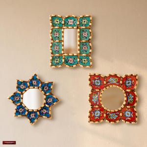 May include: Three wall mirrors with hand-painted floral patterns. One rectangular mirror has a teal frame, one star-shaped mirror is blue, and one square mirror has a red frame. Each frame features intricate multi-colored flower motifs.