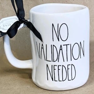 May include: White ceramic mug with a black handle and the text "NO VALIDATION NEEDED" in black lettering.