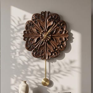 May include: A dark brown wooden wall clock featuring an intricate carved floral pattern with a circular centre. The clock has thin gold-coloured hands and a long, slender gold-coloured pendulum rod ending in a smooth, circular gold-coloured weight.