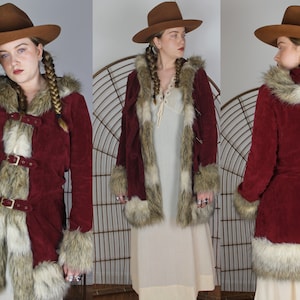May include: A long, burgundy corduroy jacket with a faux fur trim around the hood, cuffs, and hem. The jacket has a belt and multiple buckles.