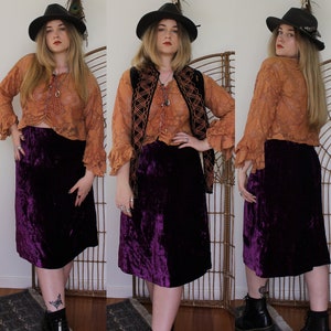 May include: A purple velvet skirt with a crushed velvet texture. The skirt is knee-length and has a straight silhouette.