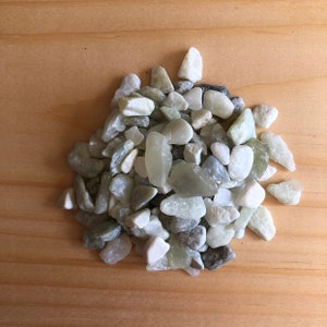 May include: A pile of small, smooth, white and green stones. The stones are various shapes and sizes.