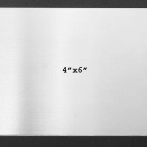 May include: A blank, silver, rectangular metal sheet with the text "4" x 6" printed in black.