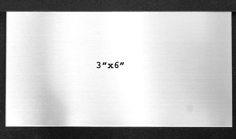 May include: A blank, silver metal plate with a brushed finish. The plate is 3 inches by 6 inches.