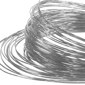 May include: A coil of silver-colored wire, tightly wound and arranged in a circular pattern. The wire is smooth and shiny, reflecting light.