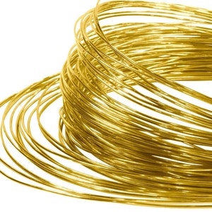 May include: A close-up of a coil of shiny gold wire. The wire is tightly wound and creates a spiral pattern.