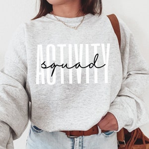May include: A gray sweatshirt with the text "ACTIVITY squad" printed in white and black.