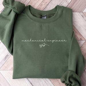 May include: A dark green sweatshirt with the text "mechanical engineer" in white lettering and a small white flower graphic.