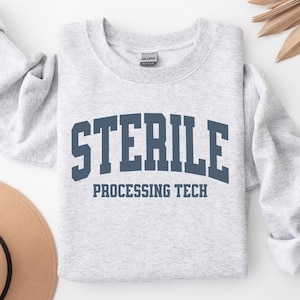 May include: Light gray sweatshirt with the word "STERILE" in navy blue block letters above "PROCESSING TECH". The sweatshirt is a crew neck style and appears to be made of a soft material.