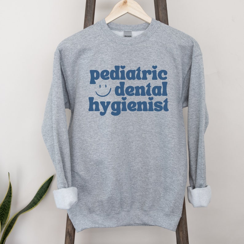 May include: Gray sweatshirt with the text "pediatric dental hygienist" in blue with a smiley face.