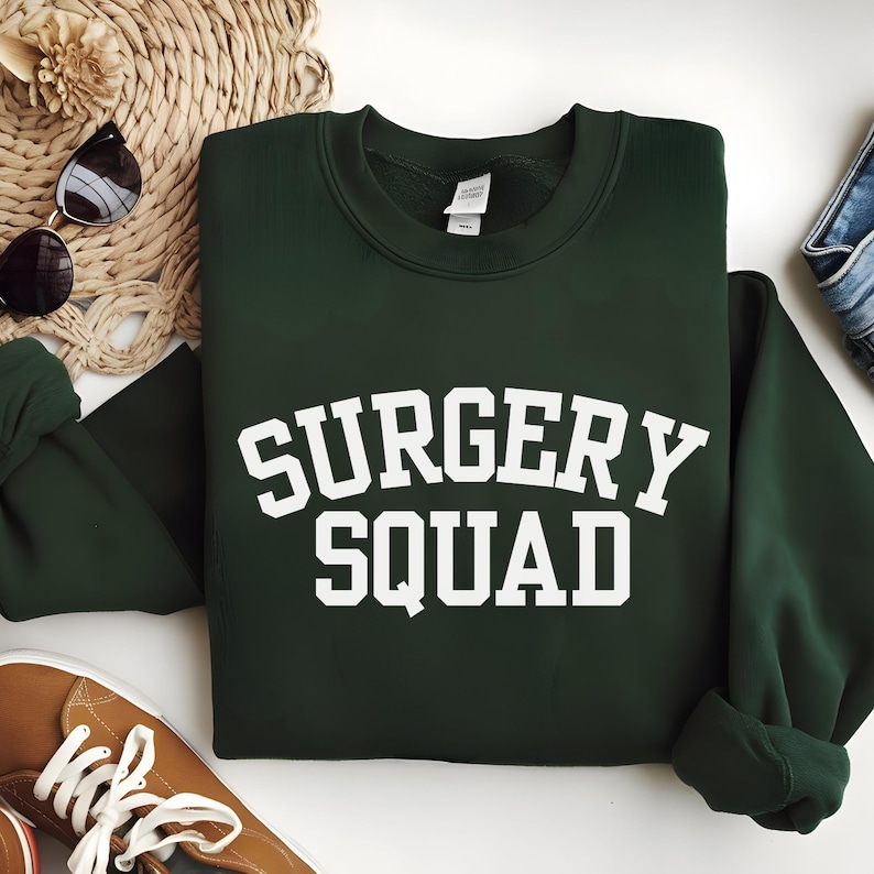 May include: A dark green sweatshirt with the text "SURGERY SQUAD" in white.