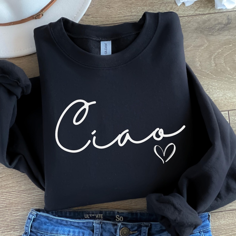 May include: Black sweatshirt with a white cursive "Ciao" and a small white heart.