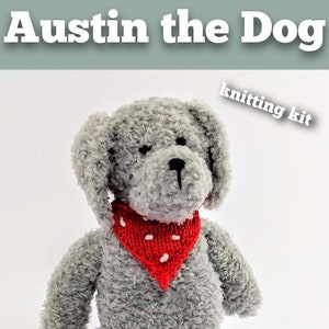 May include: Knitting kit for a gray plush dog named Austin, wearing a red bandana with white polka dots. The dog is sitting with its paws outstretched.