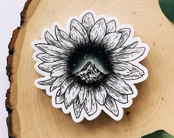 May include: A black and white illustration of a sunflower with a mountain range and starry sky inside the center of the flower.