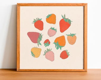May include: A framed print with a white background featuring a collection of red, orange, pink, and green strawberries. The strawberries are arranged in a circular pattern.