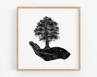 Puede incluir: Lámina artística en blanco y negro que muestra un árbol que crece de una mano. La mano está llena de un diseño de noche estrellada. La obra de arte está enmarcada en un marco de madera clara, creando una estética minimalista.