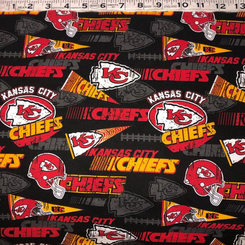 May include: Black fabric with a repeating pattern of red, yellow, and white Kansas City Chiefs logos. The logos include the team name, the city name, and the team's arrowhead logo. The fabric is perfect for crafting projects like pillows, blankets, and tote bags.