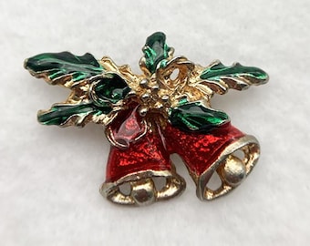 May include: A gold-tone Christmas pin with two red bells and green holly leaves.