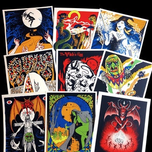 May include: A collection of ten colorful art prints with occult and fantasy themes. Each print features unique illustrations with vibrant colors, including images of witches, demons, and surreal landscapes. The prints are arranged on a black surface.
