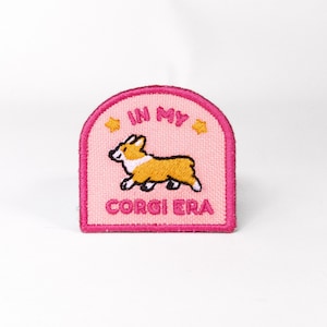May include: Pink and white embroidered patch with a cartoon corgi and the text "In My Corgi Era".