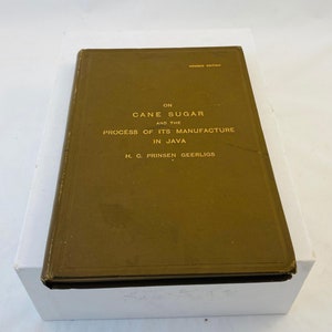 May include: A brown book with gold lettering on the cover. The title is "On Cane Sugar and the Process of Its Manufacture in Java" by H. C. Prinsen Geerligs.