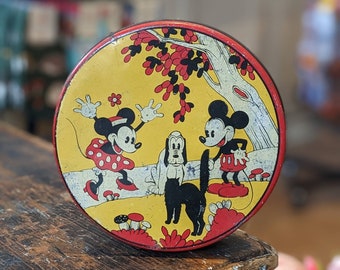 May include: Vintage tin lunchbox featuring Mickey Mouse, Minnie Mouse, and Pluto in a forest setting. The lunchbox is yellow with red accents and features a black and white dog.