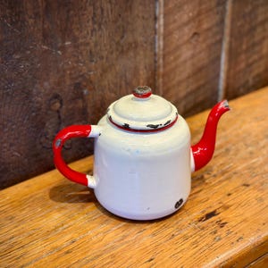 Bule de chá ou cafeteira vintage com esmalte vermelho e creme