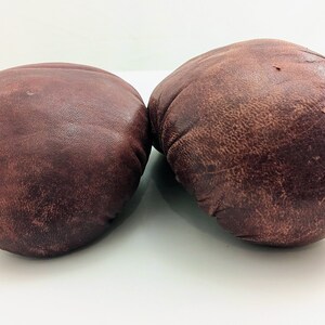 Puede incluir: Un par de guantes de boxeo de cuero marr&oacute;n. Los guantes est&aacute;n usados y tienen un aspecto desgastado.