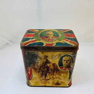 May include: A vintage tin box with a Union Jack design and images of military figures. The box is decorated with a portrait of a man in a military uniform and the text "Secretary of State for the War Office".
