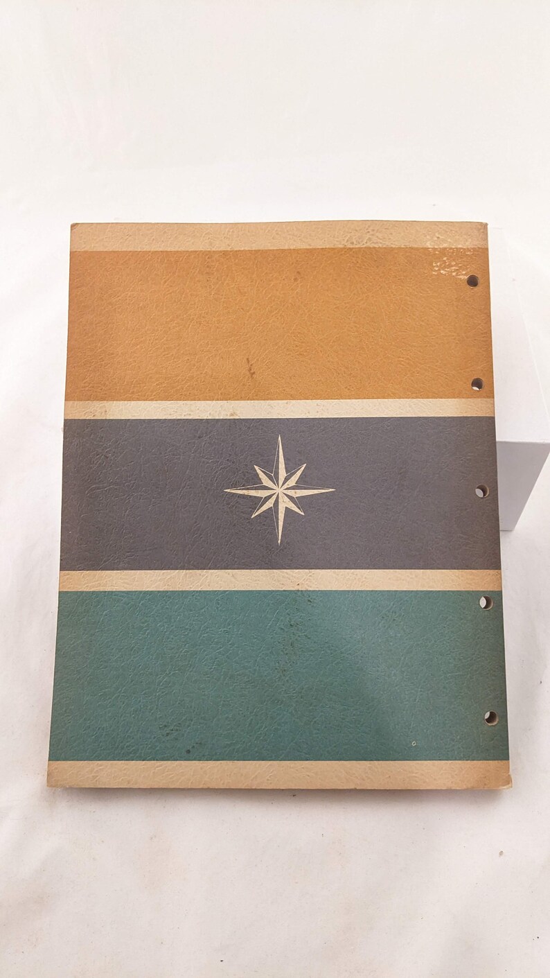 May include: A vintage three-ring binder with a brown, gray, and green striped cover. A white star is centered on the gray stripe.