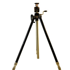 May include: A black tripod with a silver centre column and a crank handle. The tripod is made of metal and has three legs.
