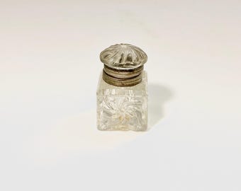 Tintero victoriano de cristal tallado con tapa abatible en diseño espiral.