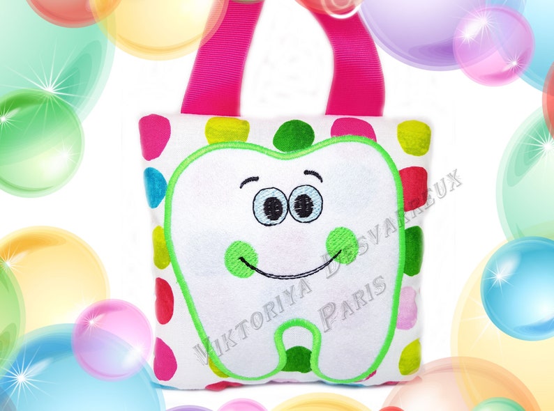 May include: A white plush tote bag with a green embroidered tooth with a smiling face and green polka dots. The bag has a pink handle and colorful polka dots.