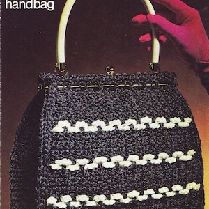 May include: A black and white crocheted handbag with a white handle. The bag has a 'Mayfair' crochet handbag label and the text 'by Atlas'.