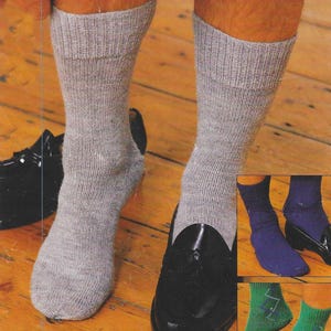 Könnte beinhalten: Drei Paar Socken in verschiedenen Farben und Mustern. Das erste Paar ist grau, das zweite Paar ist blau und das dritte Paar ist grün mit einem Rautenmuster.