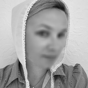 May include: A white lace bonnet with a white lace trim. The bonnet is worn over a striped shirt with a necklace.