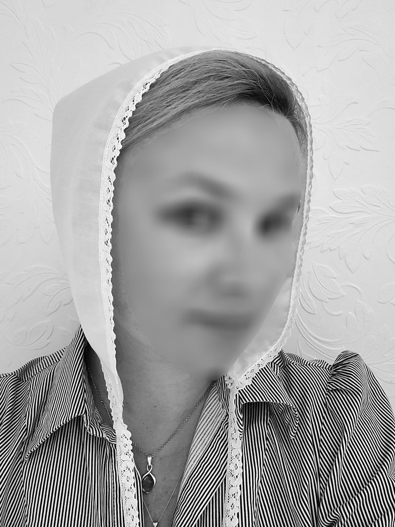 May include: A white lace bonnet with a white lace trim. The bonnet is worn over a striped shirt with a necklace.