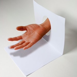 Anamorphic 3D illusion greeting card floating hand