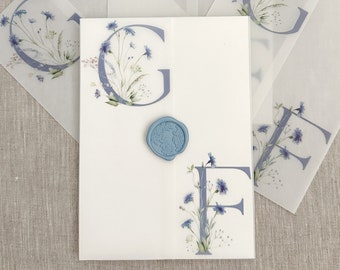 Puede incluir: Cuatro hojas de papel translúcido con un diseño floral y las letras "G" y "F" impresas en ellas. Las hojas están superpuestas, con la hoja superior teniendo un sello de cera azul.
