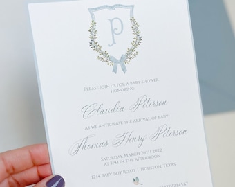 May include: A light blue baby shower invitation with a watercolor wreath and the letter "P" in the center. The invitation is for Claudia Peterson and Thomas Henry Peterson. The shower will be held on Saturday, March 26th, 2022 at 3pm at 1234 Baby Boy Road in Houston, Texas. RSVP to Alicia Blancas at (832)123.45.67. Baby registries are at Pottery Barn Kids, Amazon, and Target.